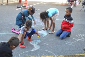 Kids draw with chalk on the street at Bronx Summer Fest 2016.